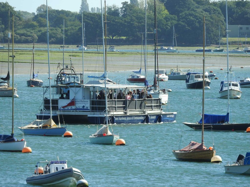 Solar Heritage weaving through the moored boats at Itchenor