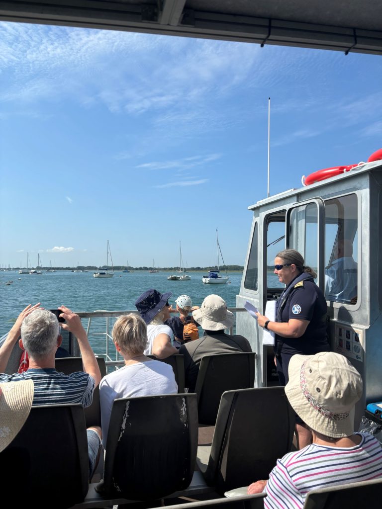 Group listening to captain on Chichester harbour boat trip 